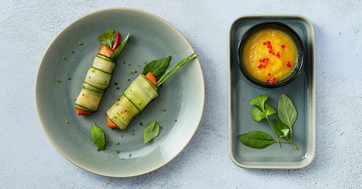 Salmon and cucumber rolls served with mango chili dip and fresh herbs.