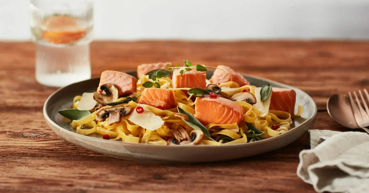 Pasta with salmon, mushrooms, sage, and chili flakes, garnished with Parmesan.
